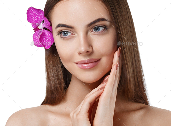 Woman beautiful portrait with flower orchid in hair is touching her face. isolated on white.