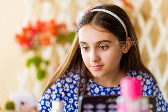Attractive young brunette girl applying makeup