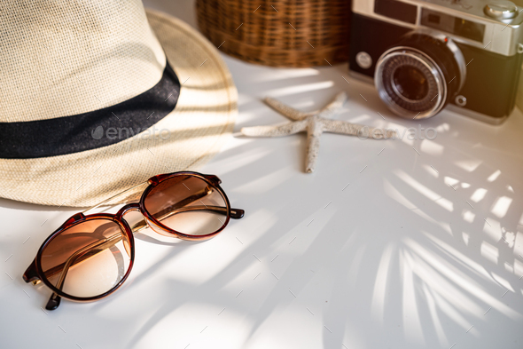 Travel accessories on the table with shadow of plam leave, Summer vacation concept