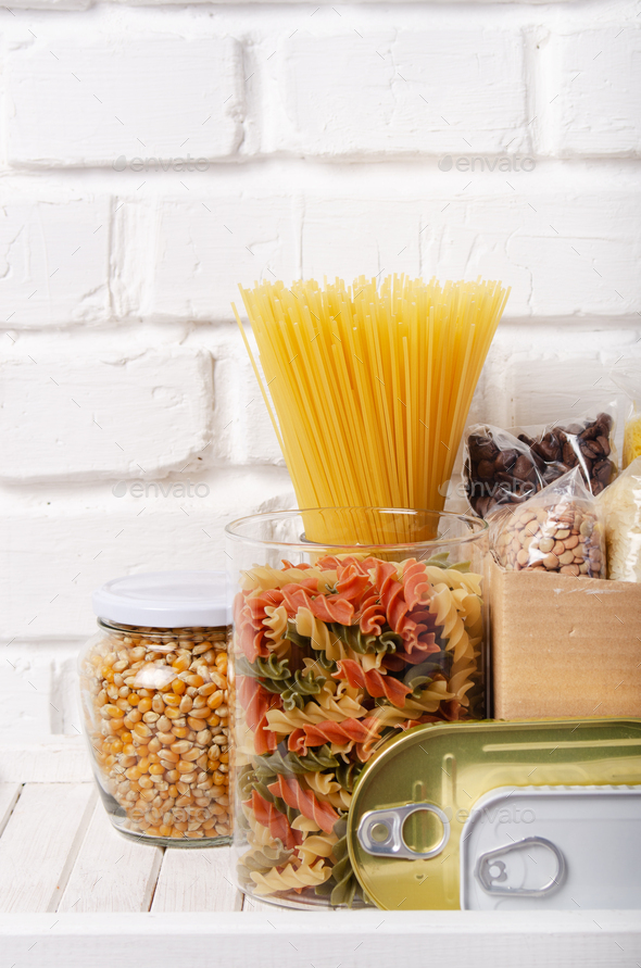 Set of uncooked foods on pantry shelf prepared for disaster emergency conditions closeup view
