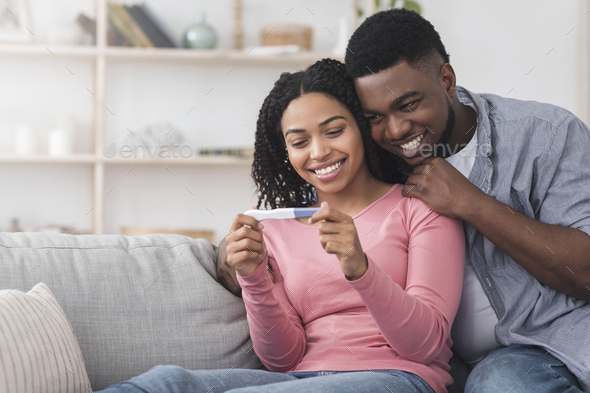 Married black couple happy with positive results of pregnancy test