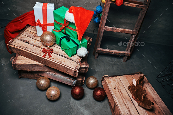 Gift boxes, tree balls, hat and bag with vintage wooden boxes and ladder.