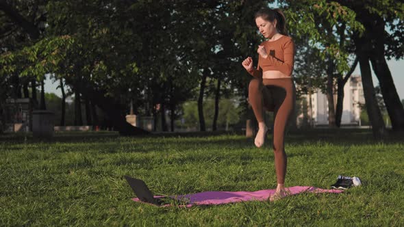 Woman working out with laptop outdoors
