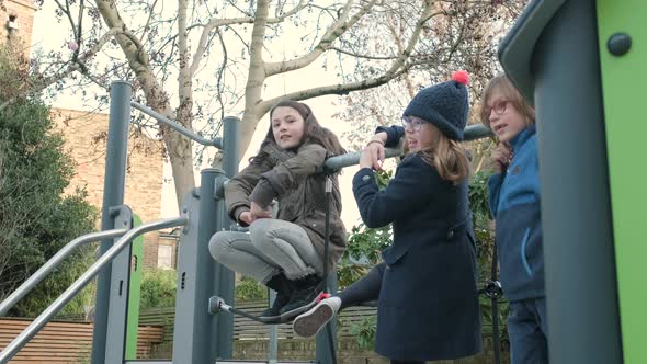 Children playing telephone game on the schoolyard during break time alt