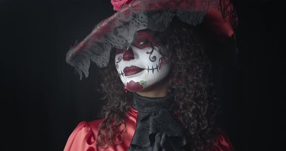 Woman in Red Dress and a Hat Wearing Skull Makeup Santa Muerte Film Grain alt