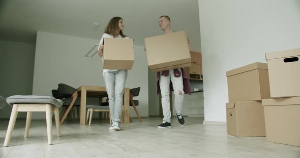 Young Couple Arriving in Apartment With Boxes