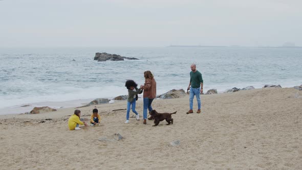 Parents Play with Children On Ocean Coast