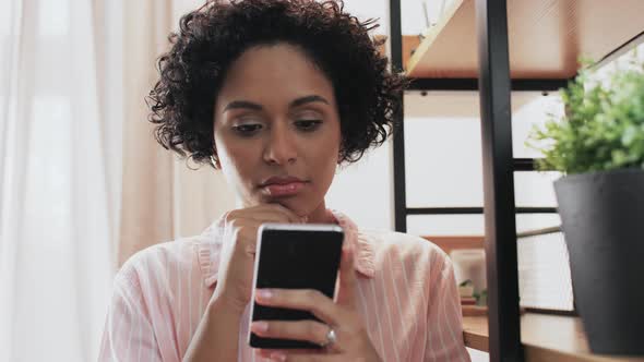 Thinking Woman with Smartphone at Home