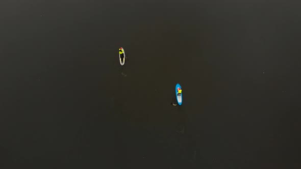 Drone Shot of Man and Woman on Sup Paddle Boards at Wide River Bird Eye View alt
