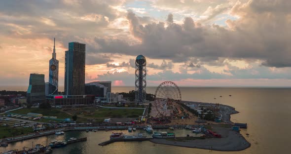 Aerial hyperlapse of Ferris wheel, alphabetic tower, skyscrapers and embankment of Batumi city alt