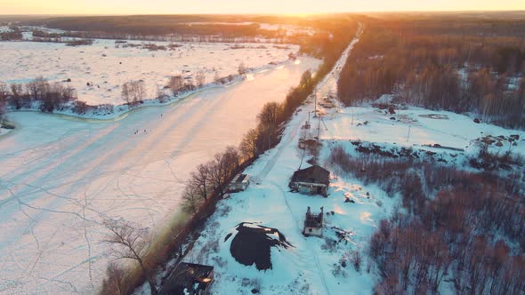 A Majestic Winter Landscape with a Frozen River at Sunset Aerial View alt