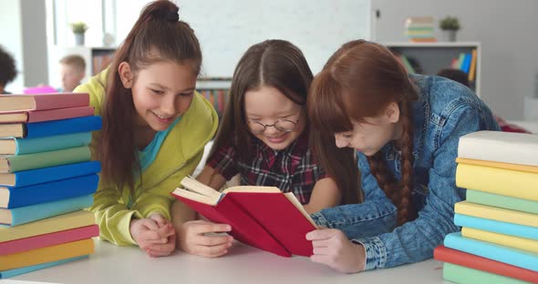 Diverse Kids Sitting at Desk and Reading Books in Classroom alt