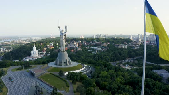 Aerial View of the Ukrainian Flag Waving in the Wind Against the City of Kyiv alt