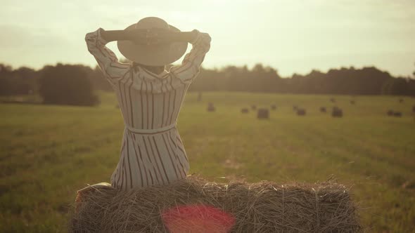 Young woman in hat enjoys life in the field