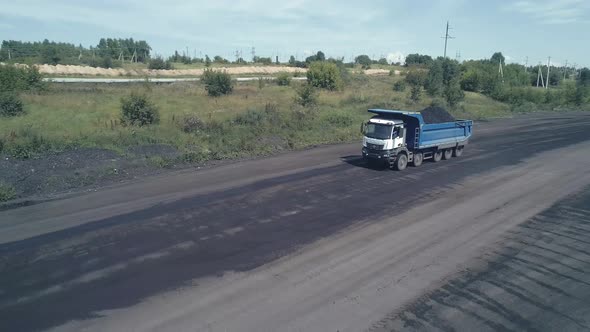 The Drone Follows a Heavy Dump Truck on a Fiveaxle Chassis