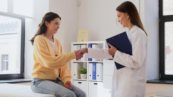 Doctor with Clipboard and Woman Meeting at Clinic