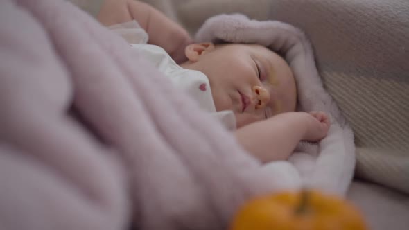 Newborn Caucasian Girl Falling Asleep Lying in Comfortable Bedroom at Home Indoors alt
