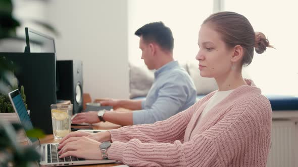 Woman Works in Text Editor at Laptop in Home Office with Partner or Spouse