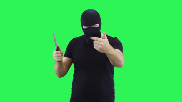 A man in a black mask holds a knife in his hand, showing that the enemy will feel  alt