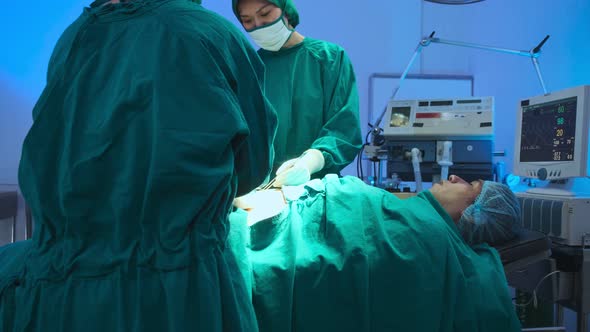 asian coworker Medical Team Performing Surgical  performing an operation alt