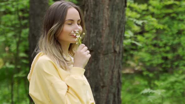 Woman Sniffs Wildflowers. Calmness and Unity with Nature alt