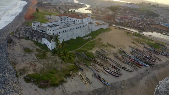 Aerial shot of the Elimina castle in Ghana during sunset alt