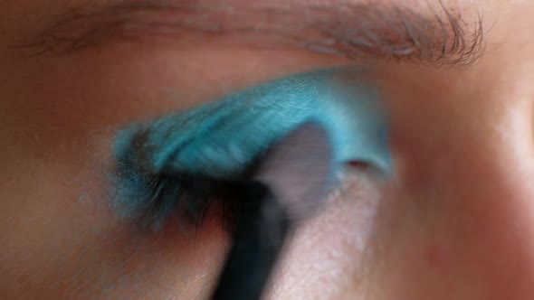 Macro Footage  Woman Puts Bright Blue Makeup on Her Eyes alt