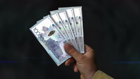 Kazakhstan Tenge money fan of banknotes in hand alt