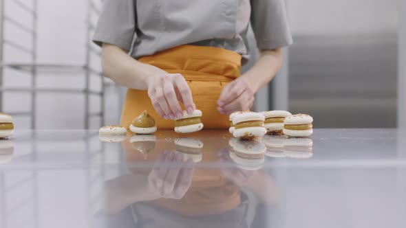 A Bright Girl Holds Fresh Cakes and Macaroons in Her Hands