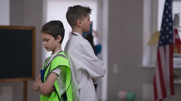 Argued Caucasian Brothers Standing Back to Back Pushing Each Other Laughing alt