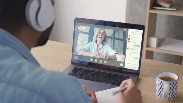 Indian Latin Businessman Having Video Call with European Woman on Laptop alt