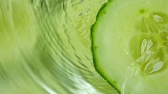 Super Slow Motion Shot of Splashing Water on Rotating Cucumber Slice at 1000Fps. alt