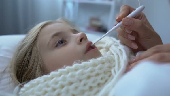 Mother Hands Putting Electronic Thermometer in Daughters Mouth, Epidemic, Health