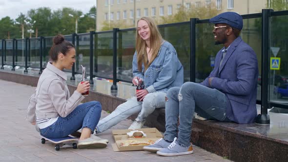 Group of young people eating on the street