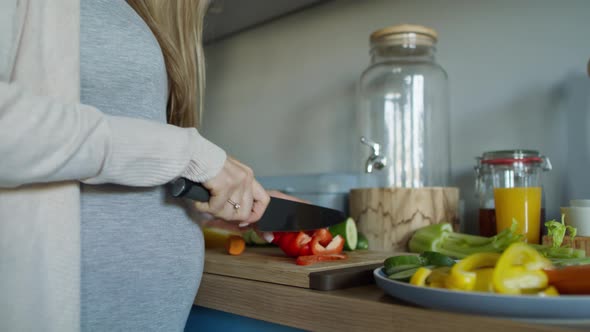 Pregnant woman preparing vegetables to eat. Shot with RED helium camera in 8K alt