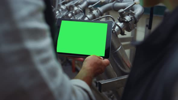 Engineer Hands Swiping Tablet with Chroma Key Screen at Steal Equipment Closeup alt