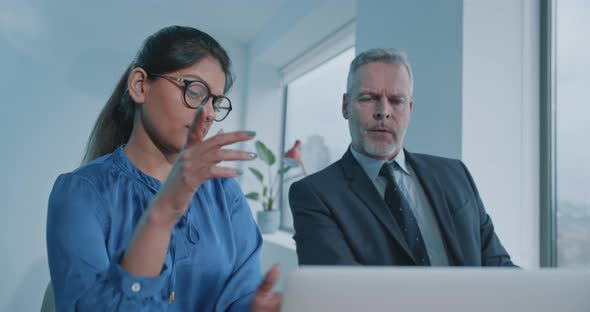 Young Indian woman presenting a project to a colleague alt