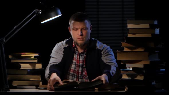 Guy Looking for the Right Information in the Book and Could Not Find It. Black Background alt