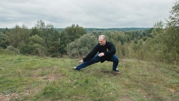 Caucasian Man is Engaged Traditional Chinese Gymnastics Qigong and Tai Chi