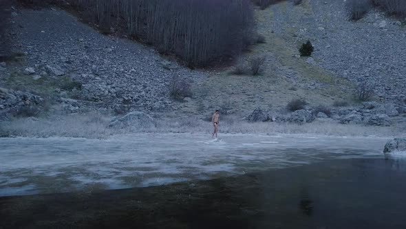 Young man walking on the ice. Top view of  frozen Lake  in Montenegro. alt