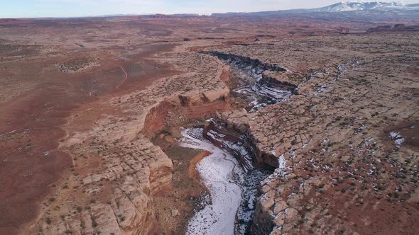 Aerial view flying over canyon cutting through the landscape in Utah alt