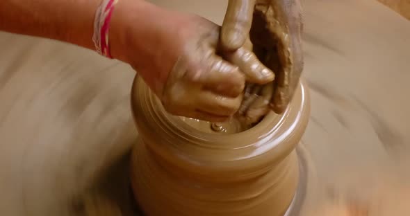 Skilled Hands of Potter Shaping the Clay on Potter Wheel and Sculpting Clay Pot Jar. Shilpagram alt