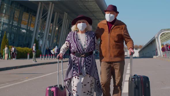 Senior Pensioner Tourists Grandmother Grandfather Walking From Airport with Luggage Coronavirus alt
