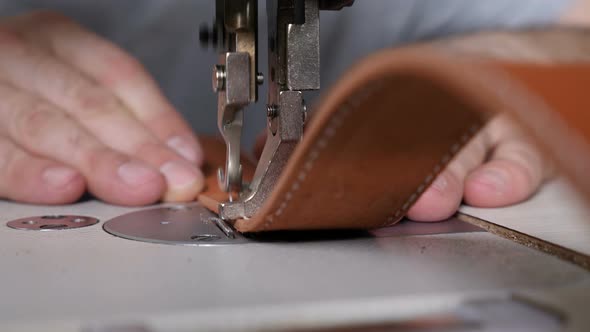Working Sewing Machine in Private Leather Craftshop, Stitching Belt in Process, Tailor at Work, Male alt