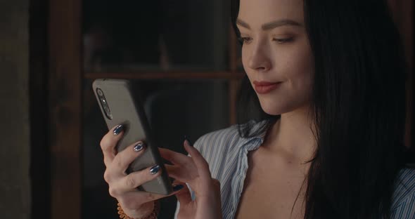 The Girl Is Looking for a Camera on Her Phone To Take a Selfie.  alt