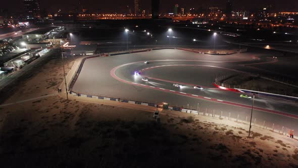 Aerial view of car racing at hairpin, Dubai Autodrome race track during night endurance competition