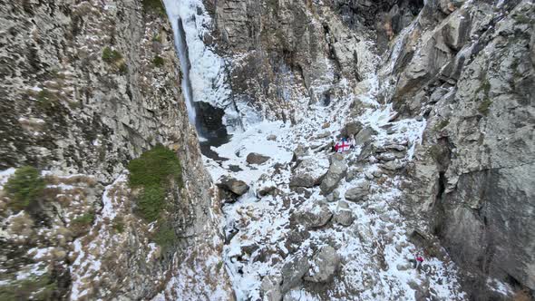 Group of People with the Flag of Georgia Near the Gveleti Waterfall in Georgia