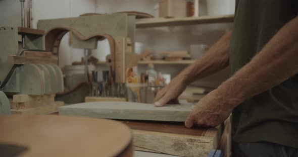 Luthier placing a mold on a wooden block