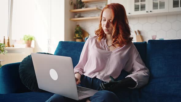 Redhaired Girl with an Unusual Appearance Who Has a Modern Prosthesis on Her Left Hand alt