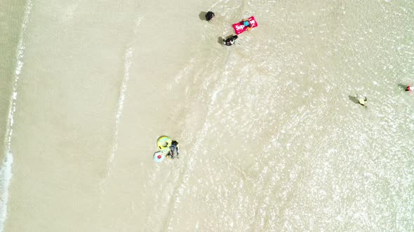 People enjoying the waves and swimming of the transparent and clean sea. Jeju Island. alt